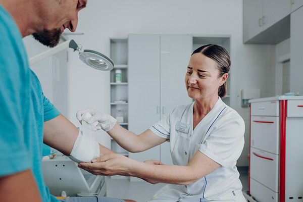 Verbandswechsel am Ellenbogengelenk eines Patienten. Verbandswechsel am Ellenbogengelenk eines Patienten.
