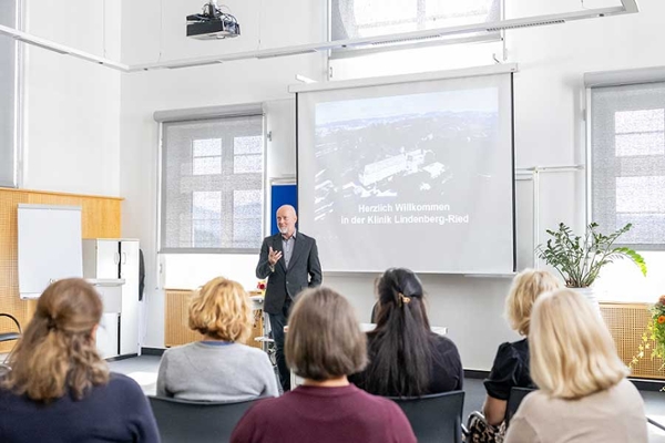 Mehrere Rehabilitanden hören sich einen Vortrag an. Mehrere Rehabilitanden hören sich einen Vortrag an.